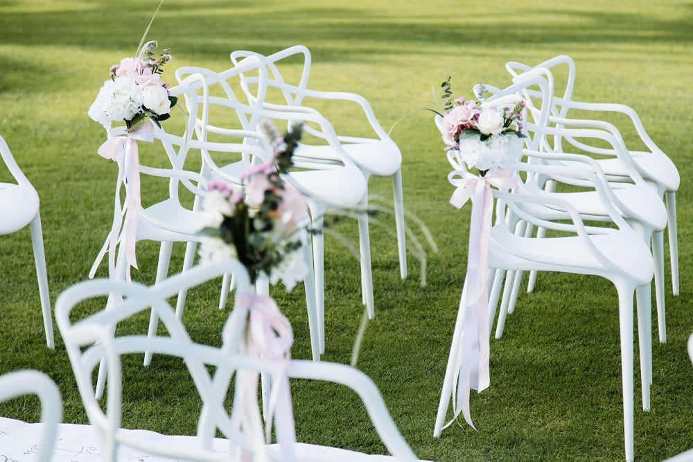 MASTERS CHAIR WHITE REPLICA with floral decor, ideal for elegant events. Lightweight, stylish design suited for weddings and corporate functions.