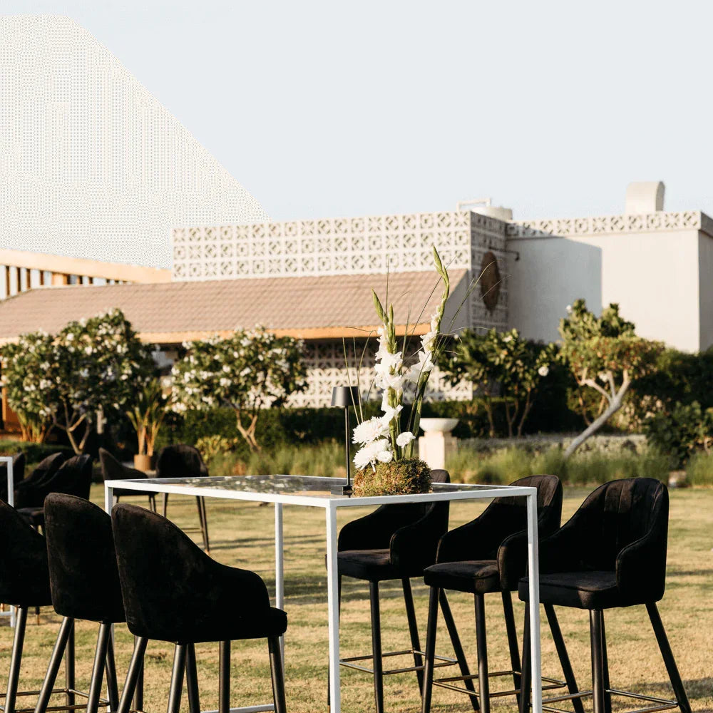 Monochromatic-Cocktail Setup featuring a table, eight stools, and a flower centerpiece, designed for outdoor gatherings, perfect for hosting events.