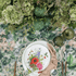 Garden Bliss- Dining Setup: A floral-designed plate with napkin and cutlery on a table, part of an elegant tableware set for eight guests.