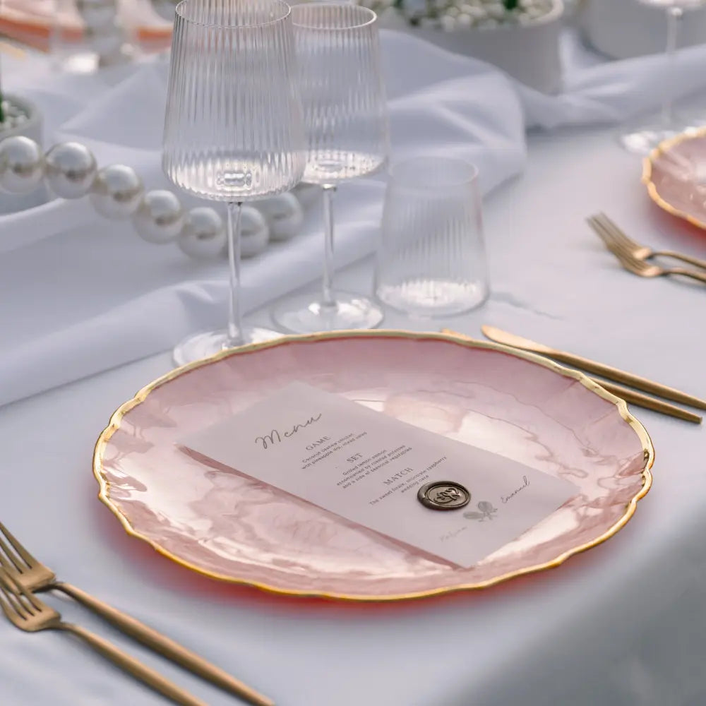 CHARGER PLATE - PINK PEARL W/ GOLD RIM elegantly displayed in a sophisticated table setting, highlighting its luxurious design ideal for upscale events.