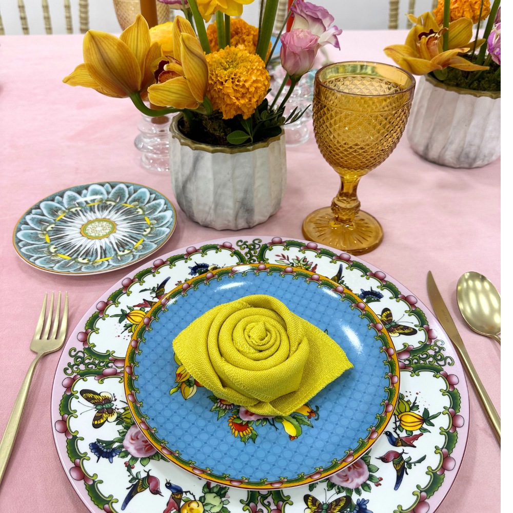 Blush Velvet Dreams-Dining Setup featuring a table with plates, floral napkins, glassware, and cutlery, ideal for an elegant event setting.