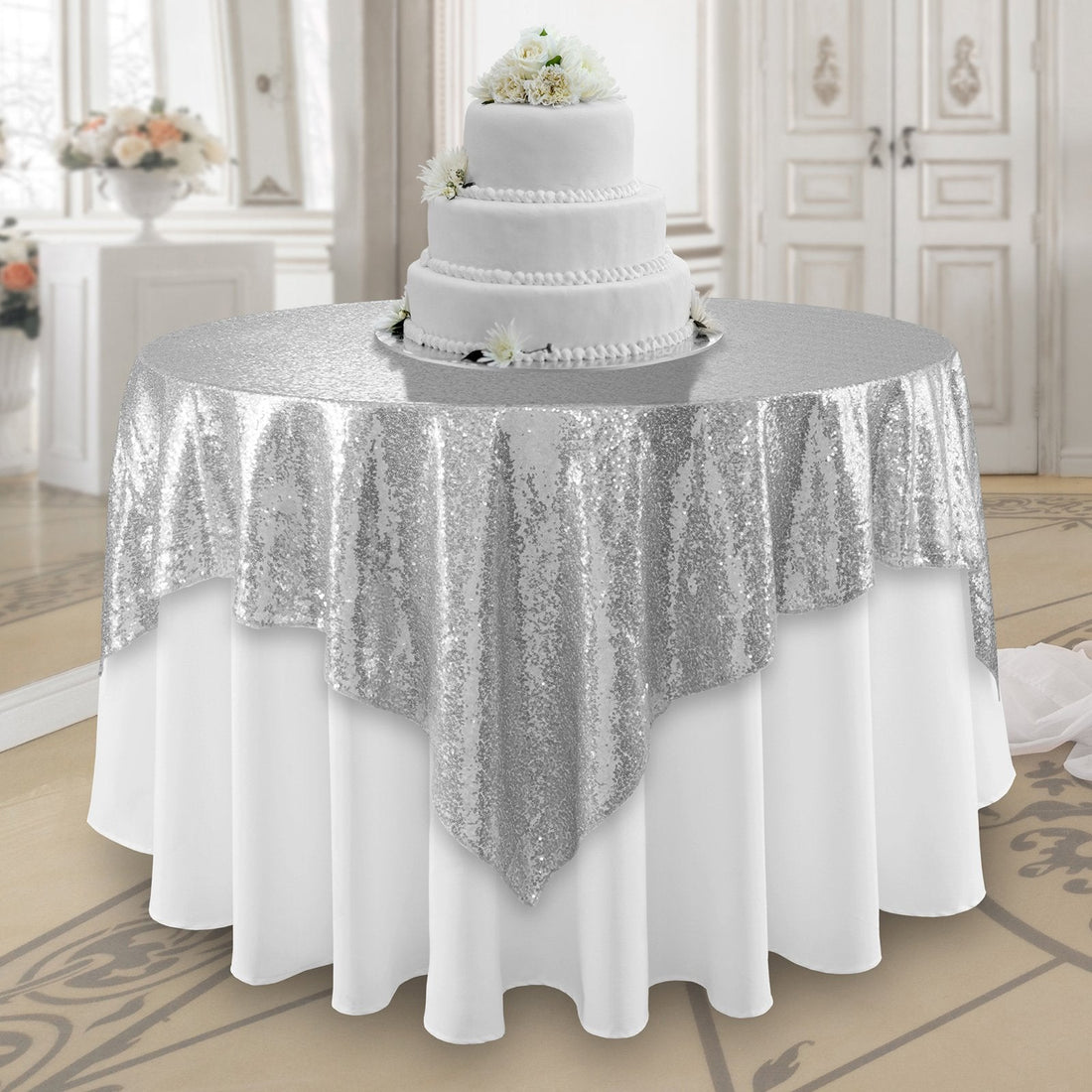 Sequin overlay on a table beneath a white cake with flowers, ideal for weddings or events, showcasing Party Social&