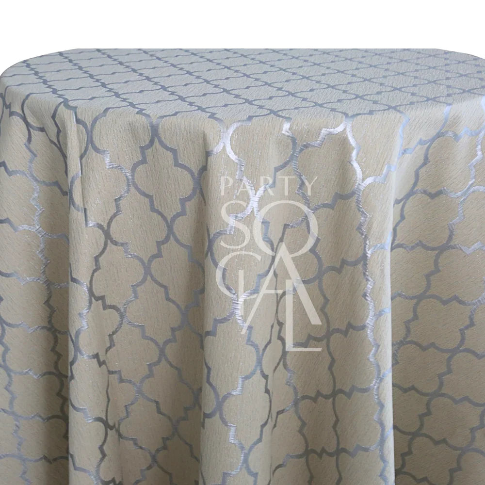IVORY AND SILVER TRELLIS TABLE CLOTH featuring a light-beige fabric with a silver quatrefoil pattern, ideal for enhancing elegant event settings.