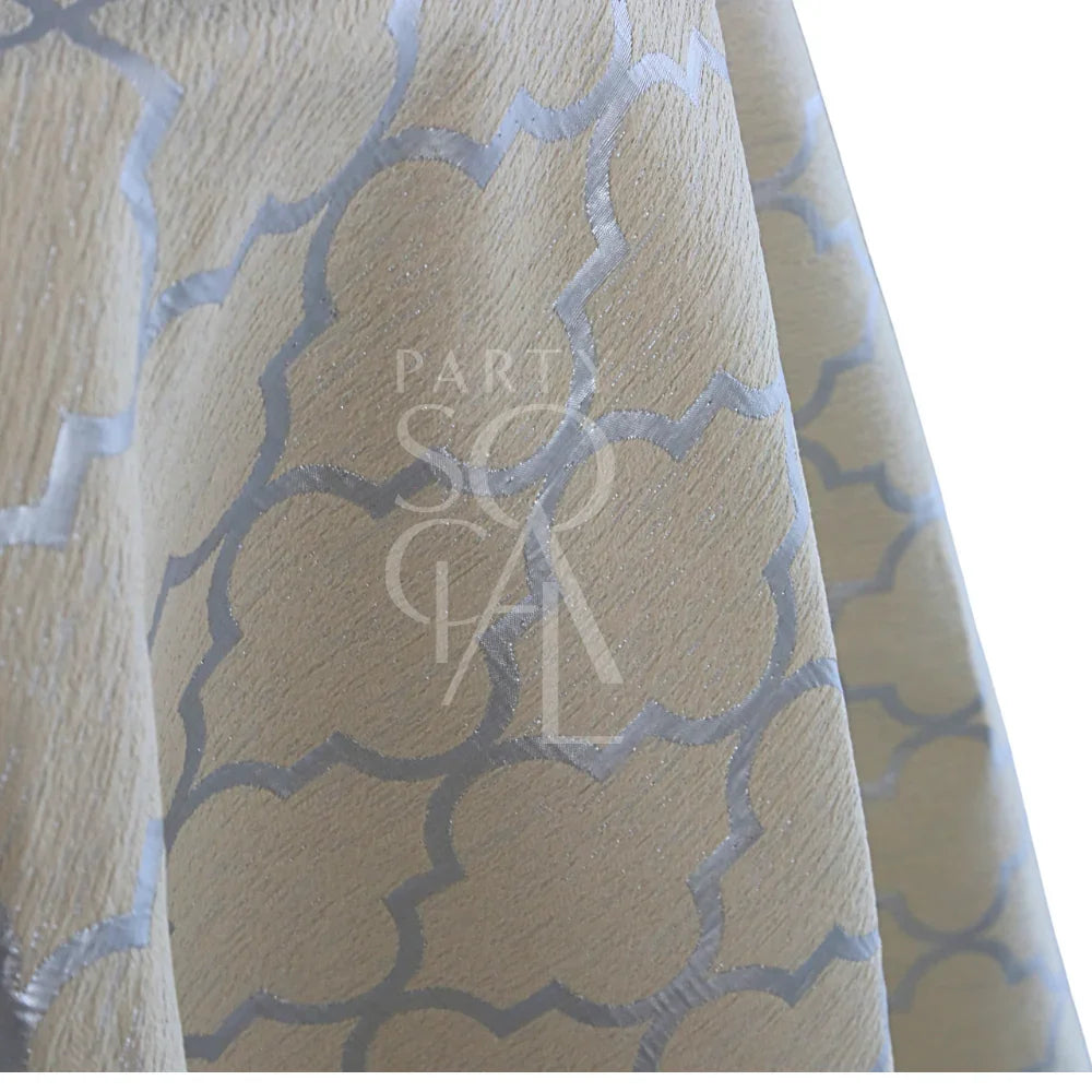 IVORY AND SILVER TRELLIS TABLE CLOTH featuring a pale beige fabric with a silvery metallic quatrefoil pattern, ideal for elegant events and celebrations.