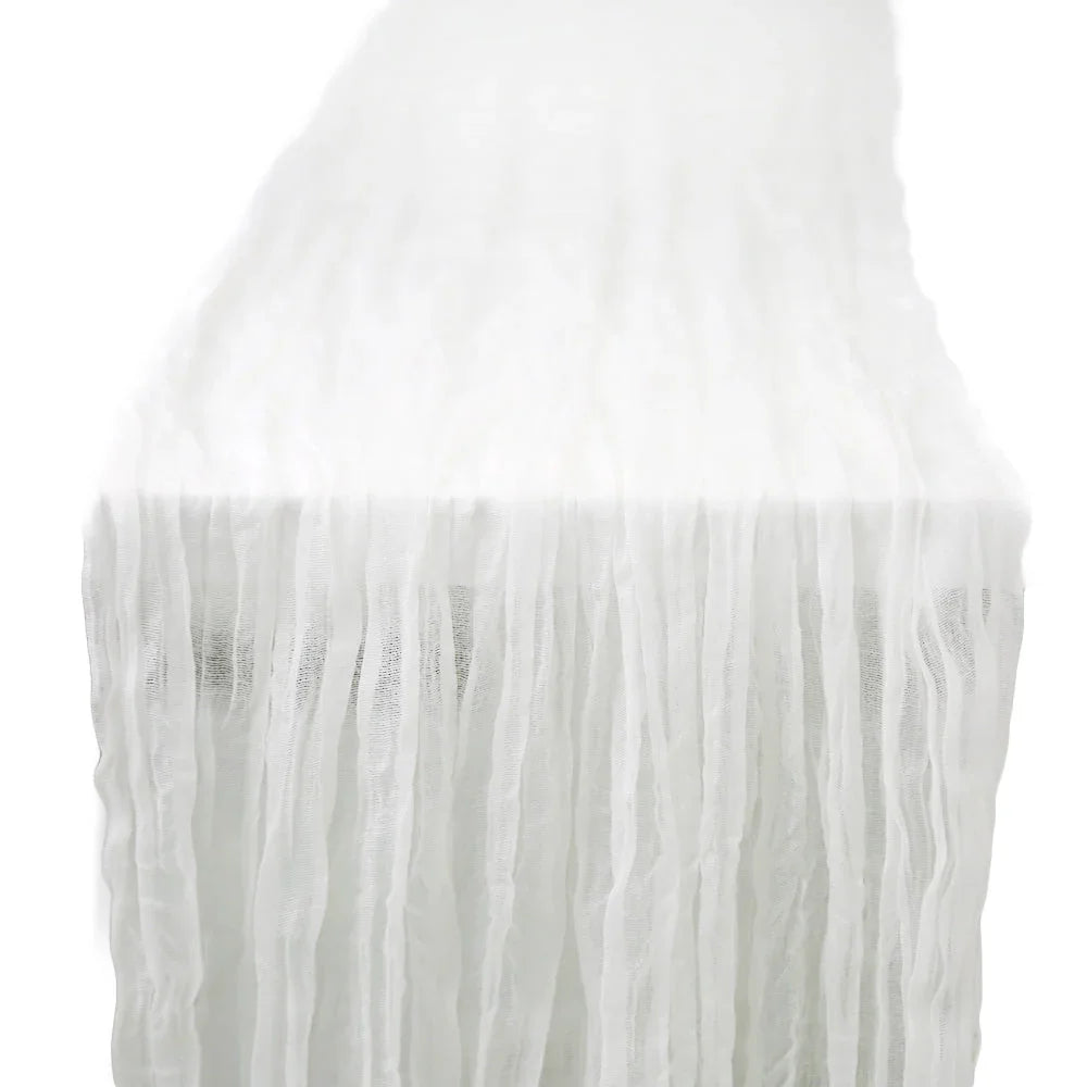Gauze table runner with fringes and a creased effect, ideal for enhancing glamorous tabletops at special events. Perfect for weddings and parties.