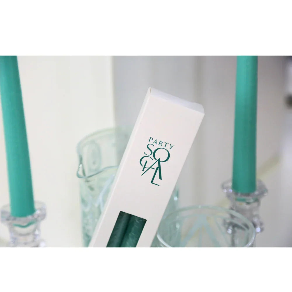 The Tapered Flame Smokeless Candles in clear glass holders, boxed set labeled PARTY SOCIAL, with textured glassware in background; perfect for elegant event settings.