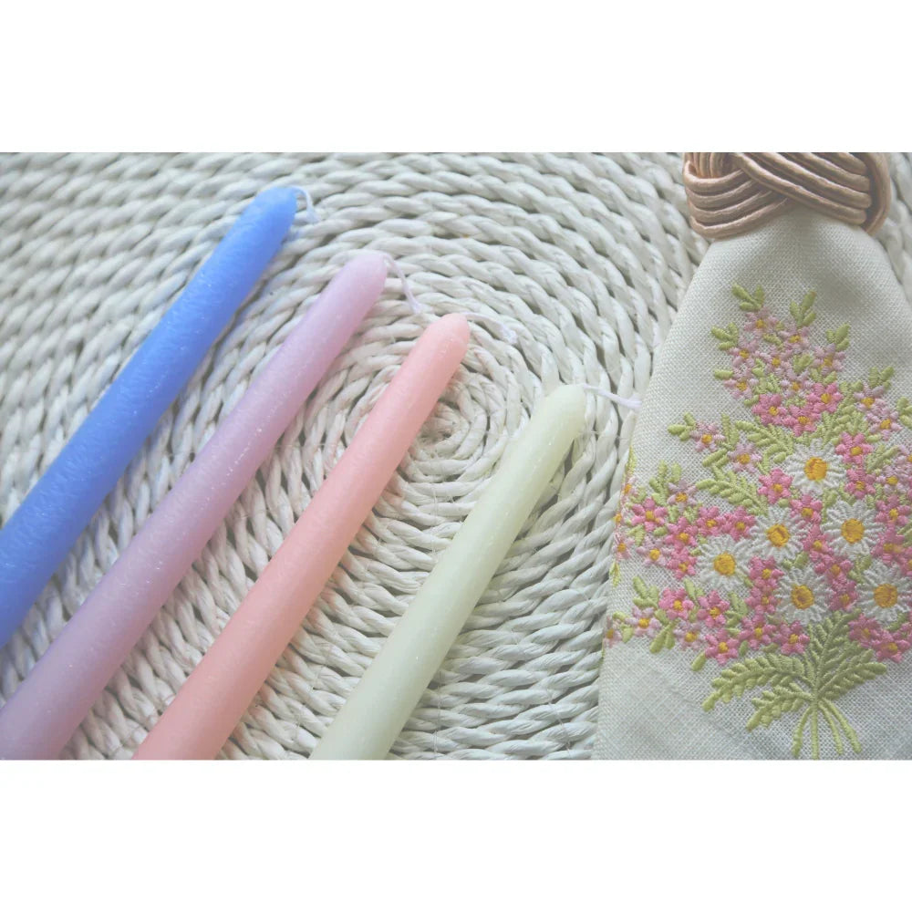 The Tapered Flame Smokeless Candles arranged with an embroidered floral pouch, showcasing artisan craftsmanship, perfect for elevating any event&