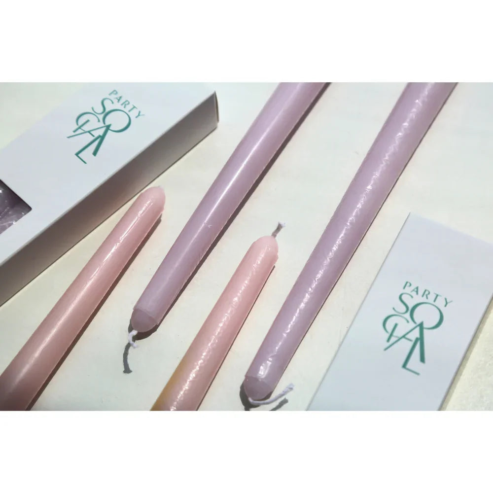 The Tapered Flame Smokeless Candles in pastel shades, packaged in PARTY SOFA boxes, perfect for adding ambience to events.