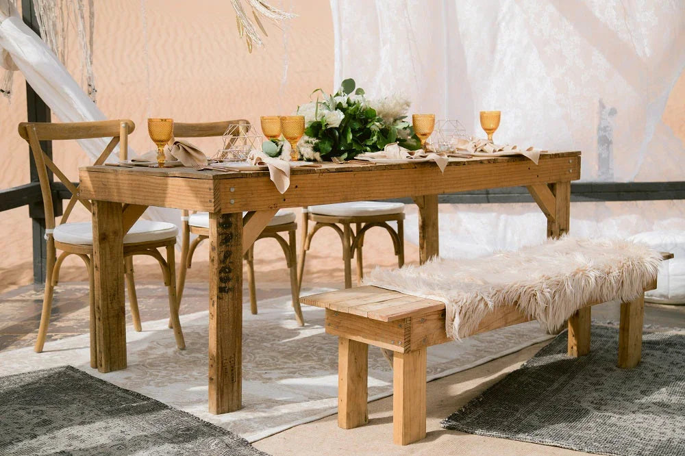 Rustic wooden bench with white fur, accommodating 3-4 people, paired with a table set for a cozy dining experience.
