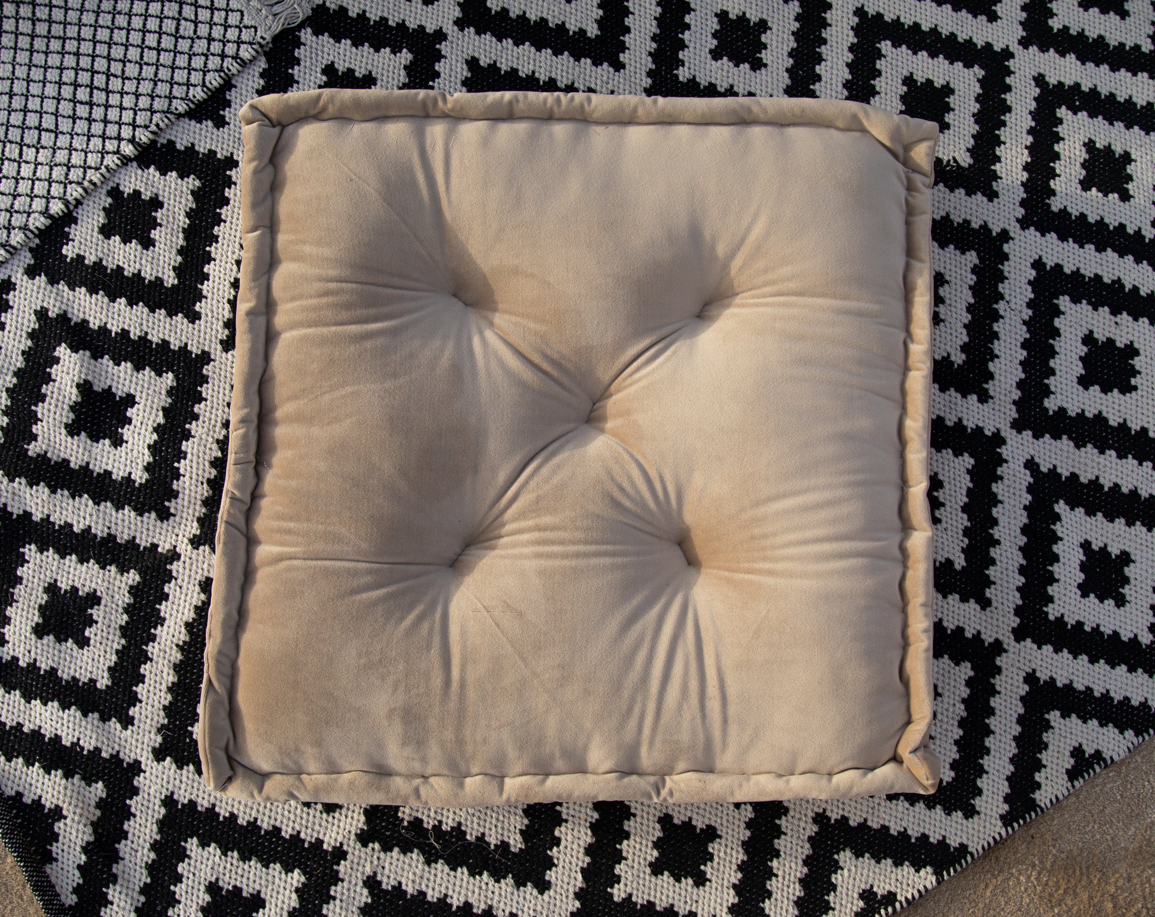 FLOOR CUSHION VELVET displayed on a textured rug, showcasing its premium velvet fabric and generous size, ideal for enhancing party and event settings.