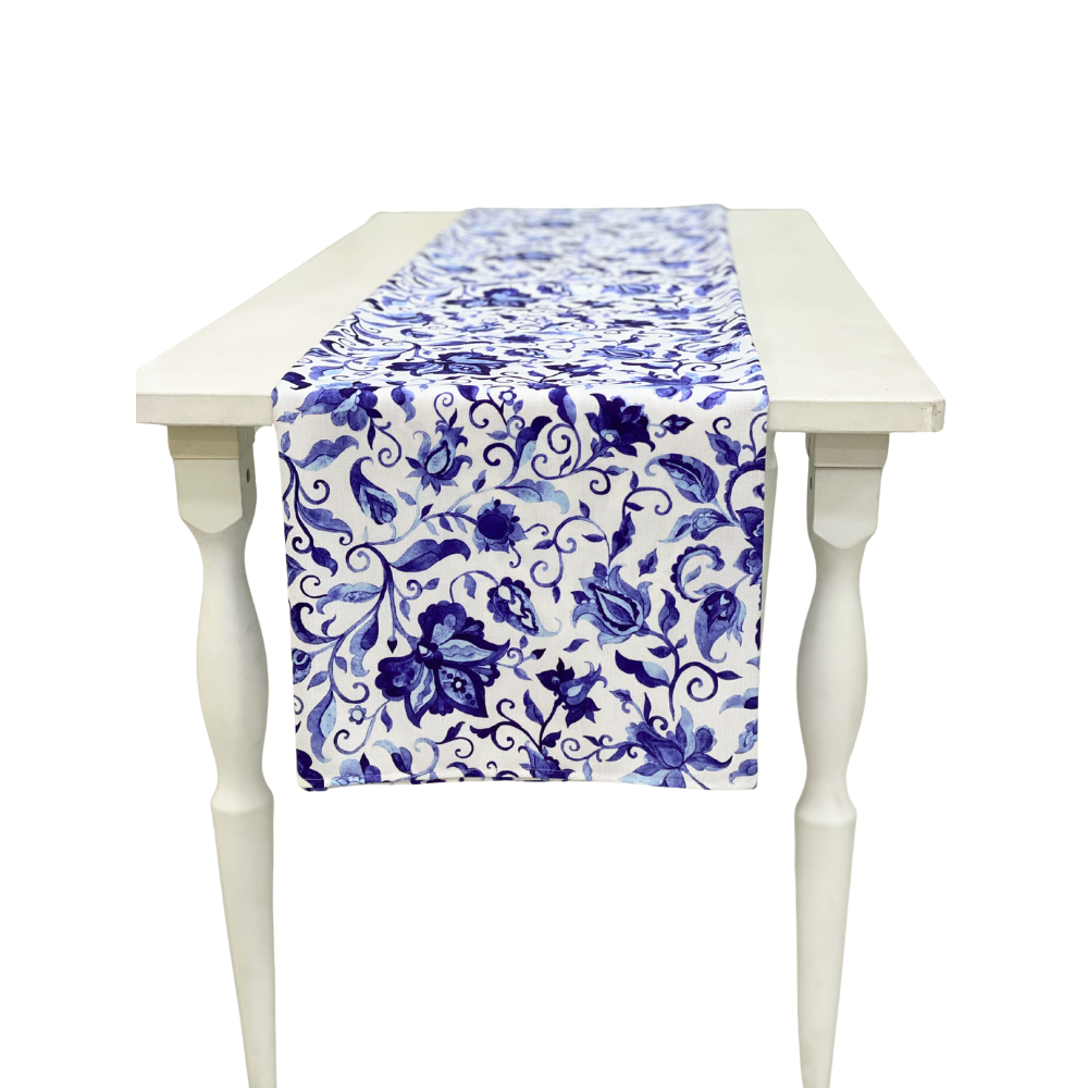Summer Florals Polyester Linen Runner on a white wooden table, featuring a blue floral pattern, perfect for enhancing special event tablescapes from Party Social.