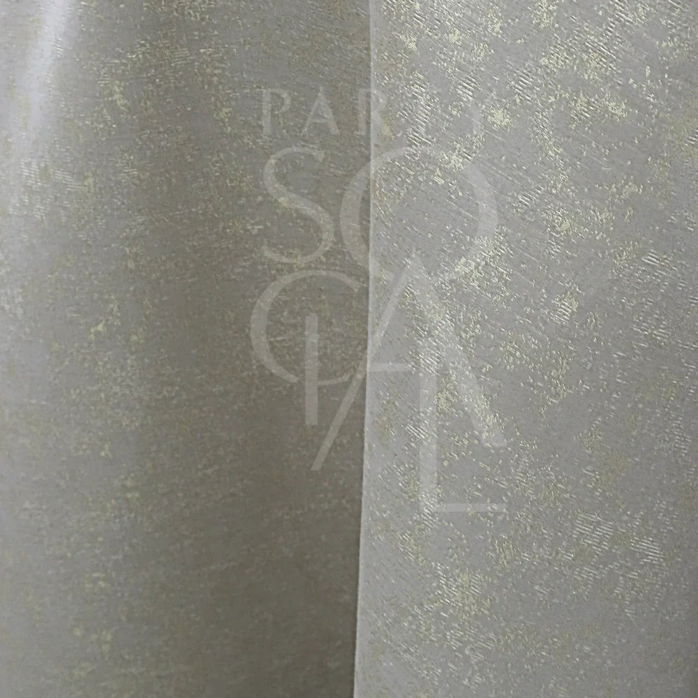 Close-up of GREY IN SHIMMERING GOLD ROUND TABLE CLOTH, featuring a light-grey fabric with a subtle metallic speckled pattern, ideal for elegant event settings.