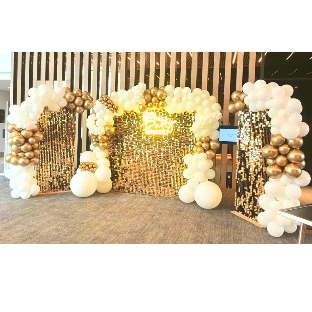 Golden Glam Wall Balloon Backdrop with gold sequin panels, white and gold balloons, and a neon sign, ideal for festive events like weddings or parties.