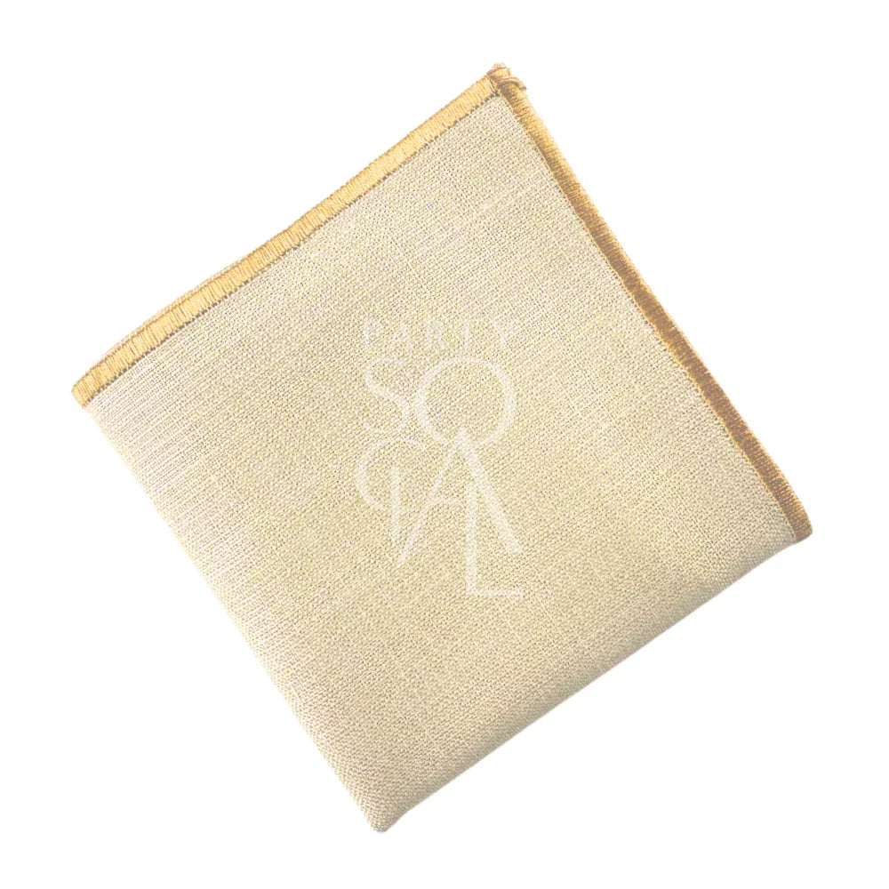 NAPKIN BLEACHED SAND W/ LINE, a close-up of a beige linen blend napkin, ideal for events. Personalization options available for weddings and corporate gatherings.