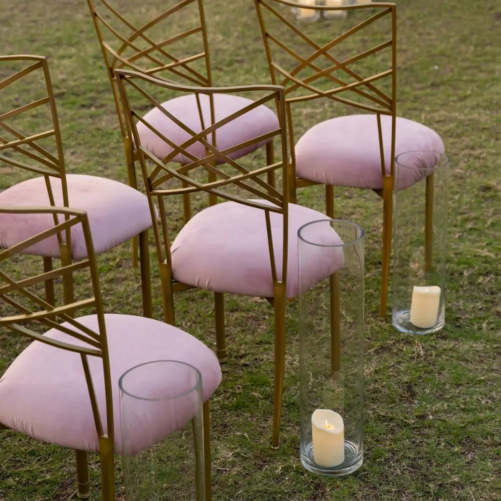 Chameleon Dining Chair with interwoven backrest in an outdoor setup, paired with glass vases holding lit pillar candles, ideal for upscale events.