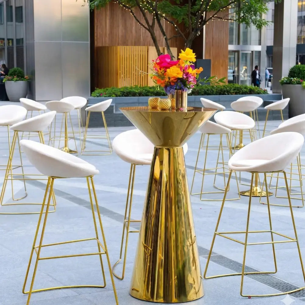 Cream and Gold Base Bar Stool with wire-frame legs and rounded white seat, set at a gold cocktail table with floral arrangement, ideal for event settings.