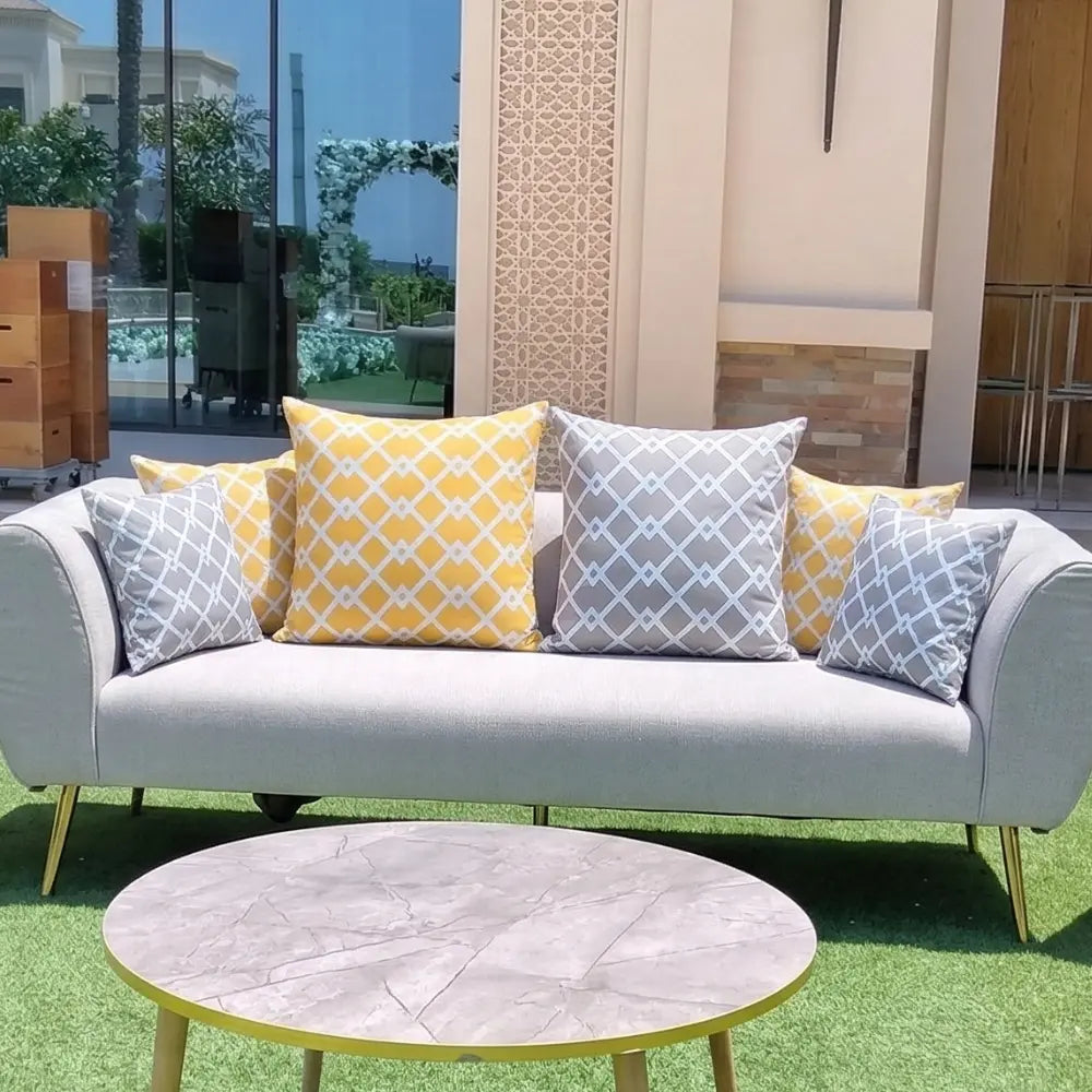 CUSHION DIAMOND PRINT on a gray sofa with geometric-patterned pillows, set in a sophisticated indoor-outdoor lounge.