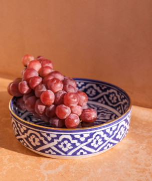 Marrakesh Patterned Ceramic Salad Bowl filled with grapes on a table.