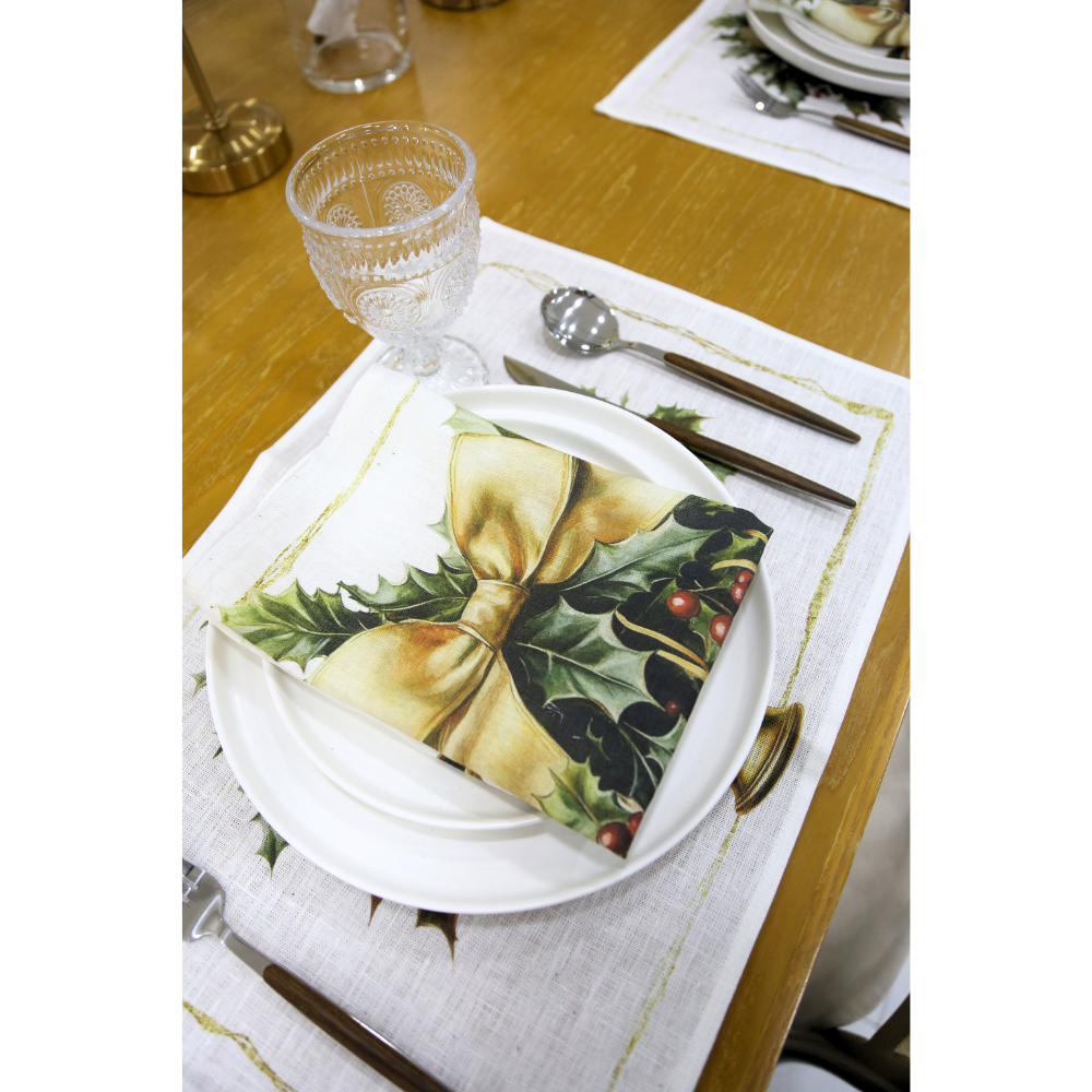 Golden Carol Linen Napkin with a golden bow and holly design, elegantly folded on a festive table setting, enhancing your holiday dining experience.