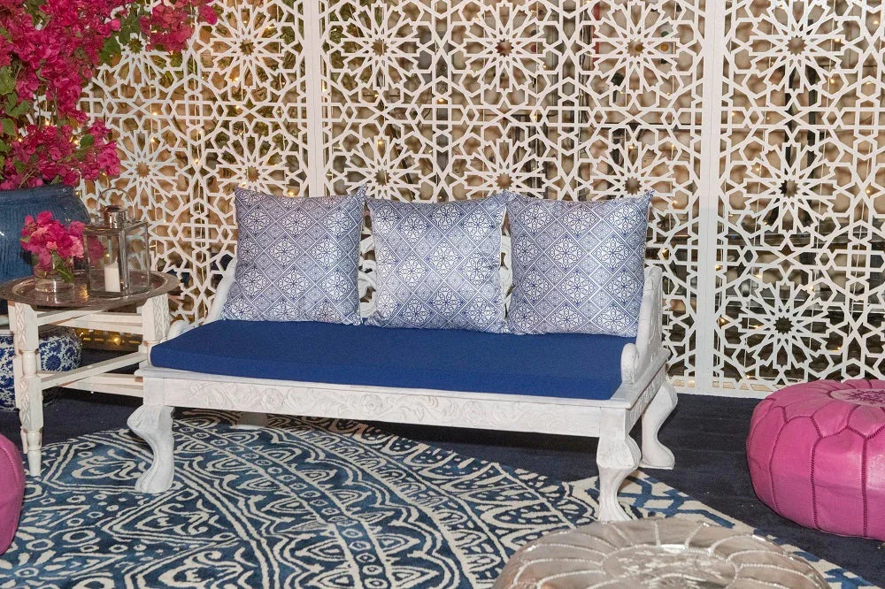 CUSHION BLUE AND WHITE MOROCCAN PRINT on a white bench, paired with other decorative blue pillows, ideal for event styling by Party Social.