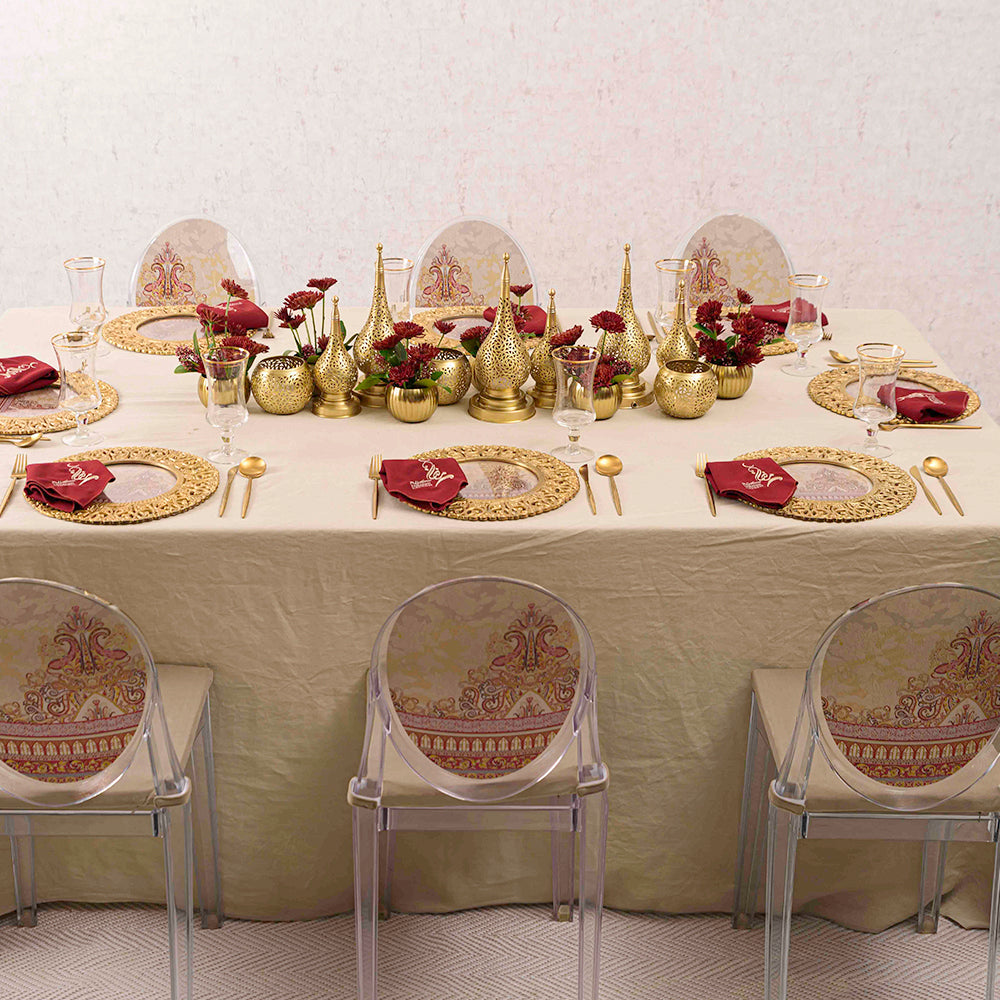 Vintage Arabesque Collection: A table adorned with gold and red decorations, featuring rental tableware and clear plastic chairs, ideal for Ramadan celebrations.