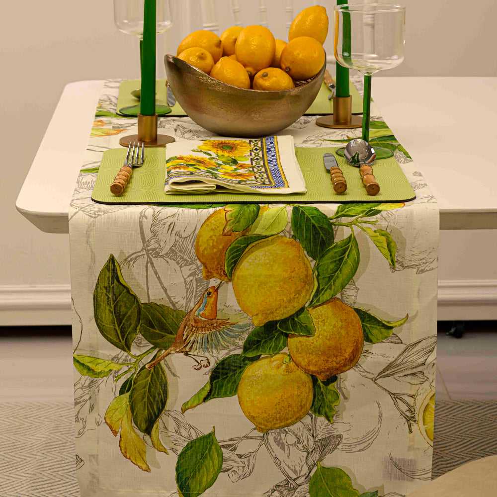 Limoncello Pure Linen Runner with lemons, candles, and glass on a table, adding elegance to any meal or event.
