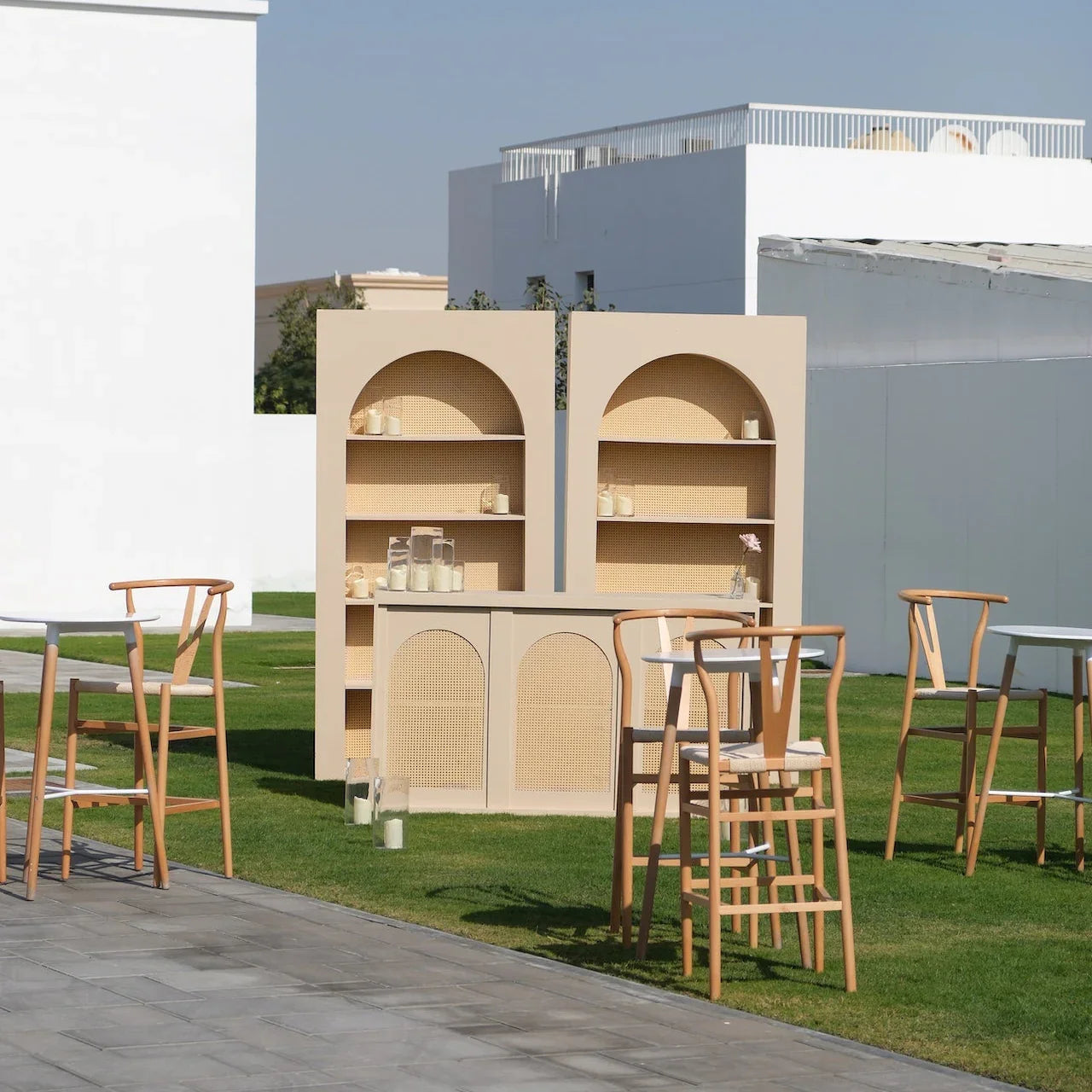 Luxe Alfresco - Dinner Setup featuring a freestanding beige bar, high-top tables, wooden bar stools, and elegant tableware for 8 guests in a minimalist outdoor lounge.