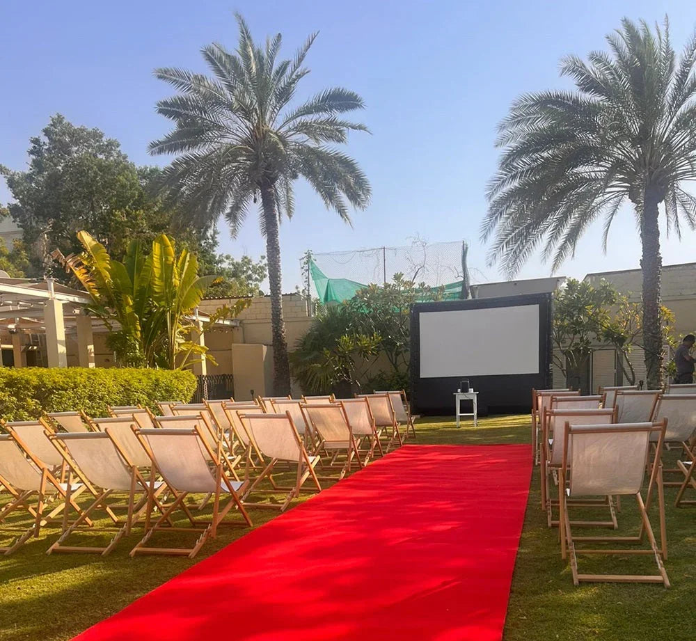 Wooden deckchairs arranged on grass, ideal for outdoor events, complementing a cinema screen setup. Perfect for backyard or beach gatherings.