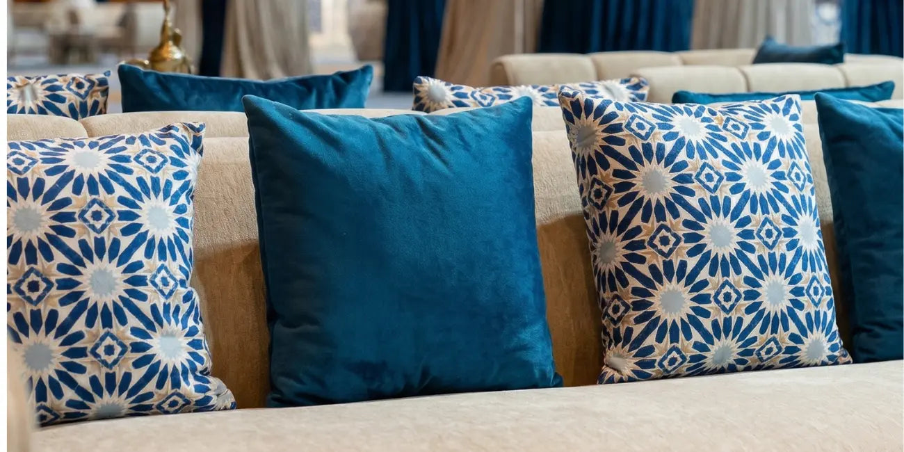 Decorative printed cushions with blue and beige patterns on a sofa