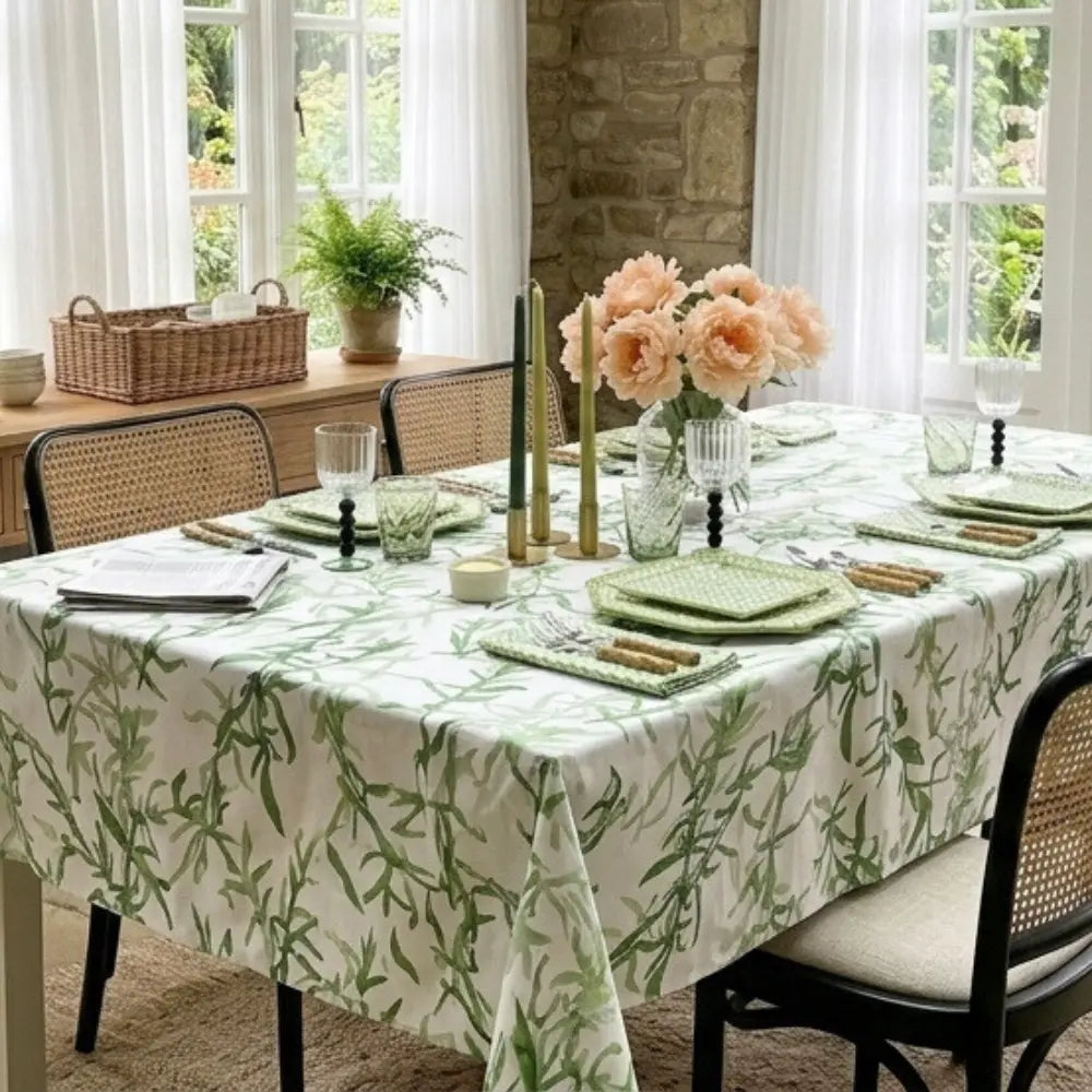 Dining table set with a green leaf-patterned tablecloth