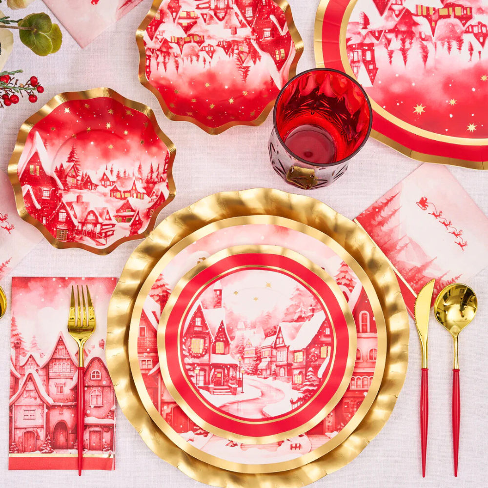 Christmas Village Cocktail Napkins on a festive table setting with plates and utensils, ideal for holiday events. Pack of 20.