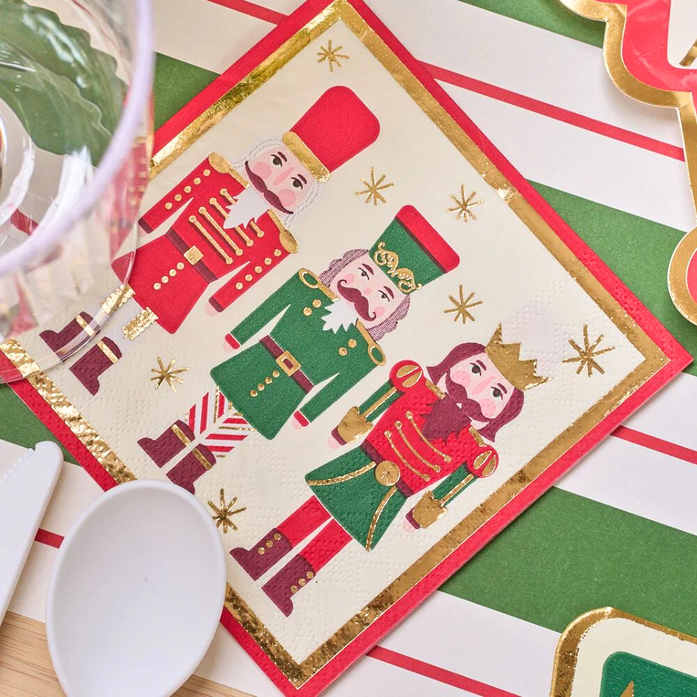 Nutcracker Cocktail Napkins featured with a festive table setting, including a glass and spoon, ideal for enhancing holiday drink presentations.