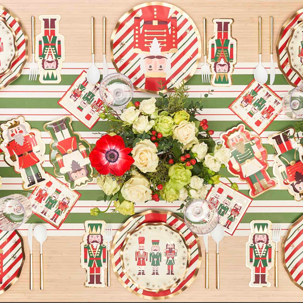 Assorted Nutcracker Salad Plates on a table with flowers, ideal for festive gatherings. Package includes eight plates, perfect for enhancing your holiday dining experience.