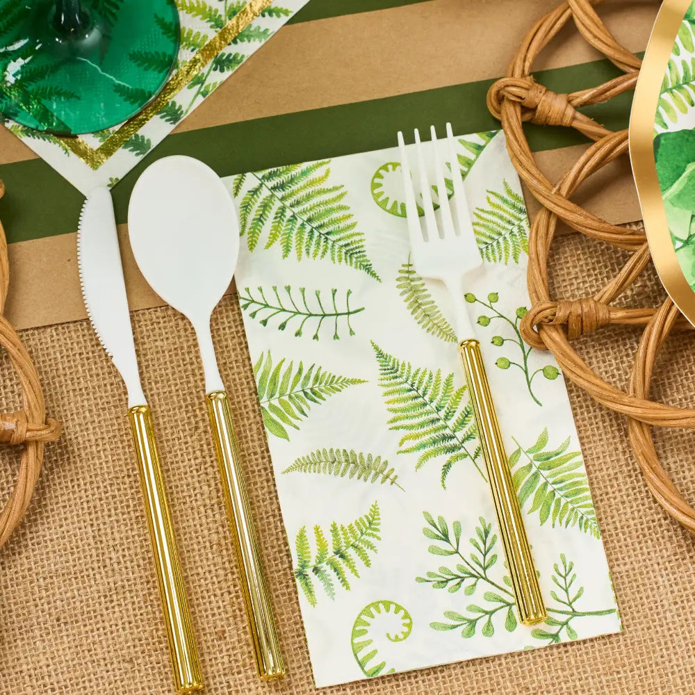 Gold cutlery set on a fern-patterned disposable napkin.