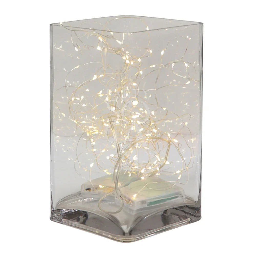 Square glass vase with string lights inside, highlighting its elegant, versatile design for home or event décor; perfect for table or console displays.