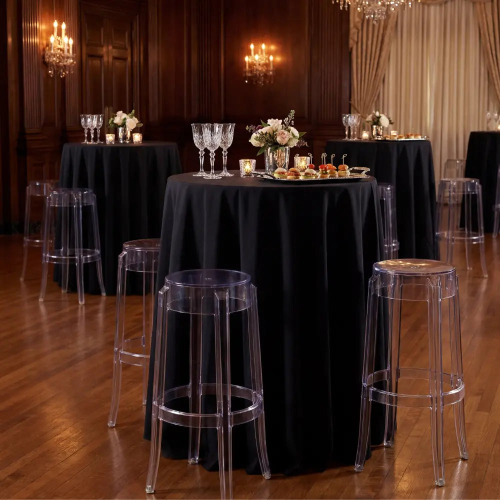 Ghost Chair Bar Stool surrounds a high-boy table with floral decor, appetizers, and crystal stemware, creating an elegant setup for intimate gatherings.