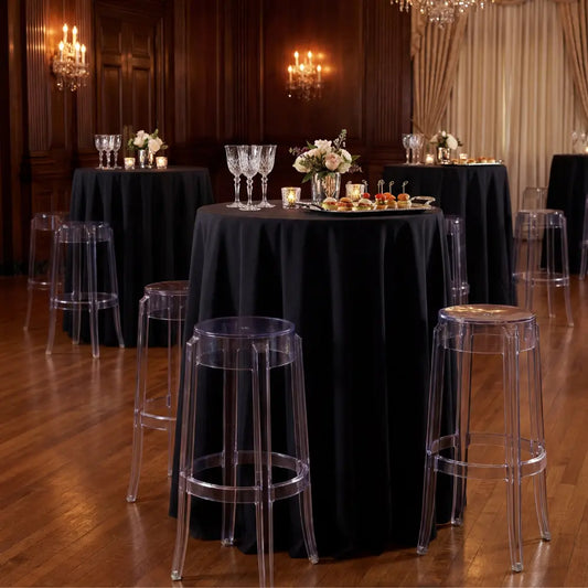 Ghost Chair Bar Stool surrounds a high-boy table with floral decor, appetizers, and crystal stemware, creating an elegant setup for intimate gatherings.