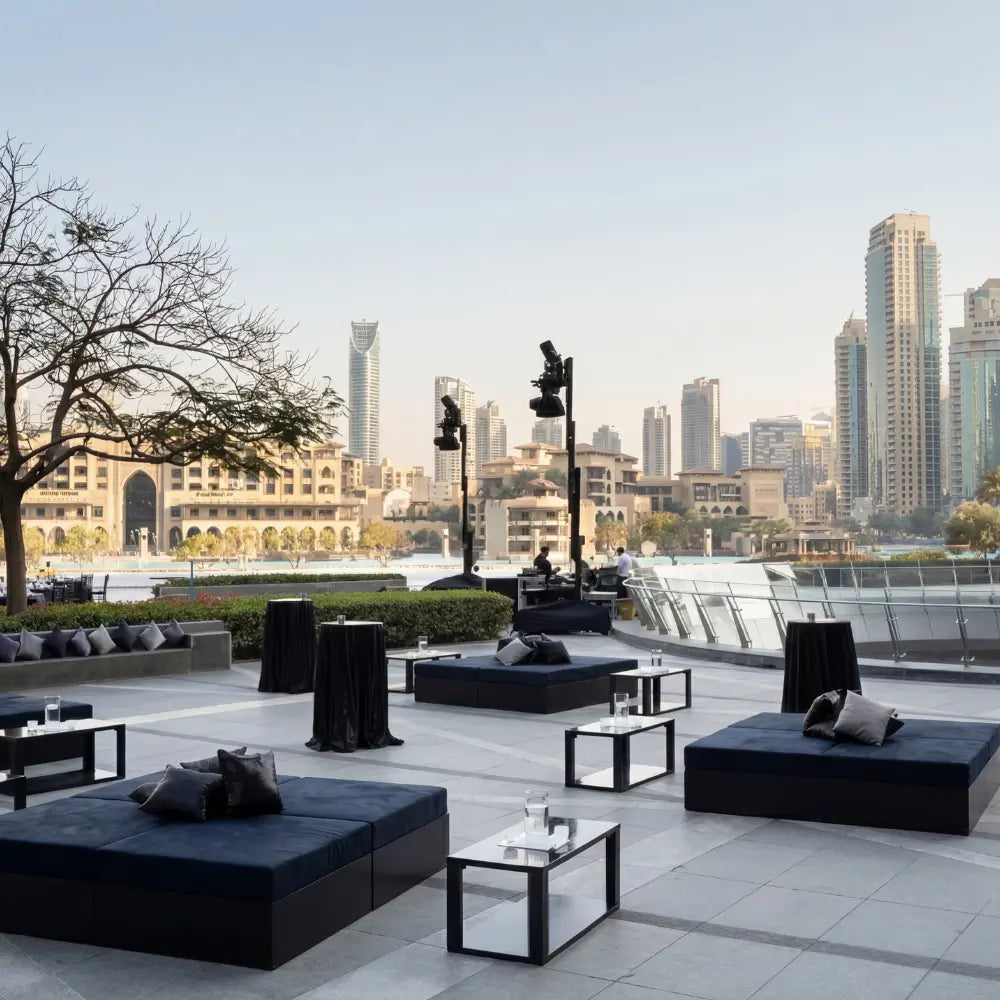 Sofa Island modular lounge seating on a chic outdoor terrace, ideal for events, with water views, lighting rigs, and urban skyline backdrop.