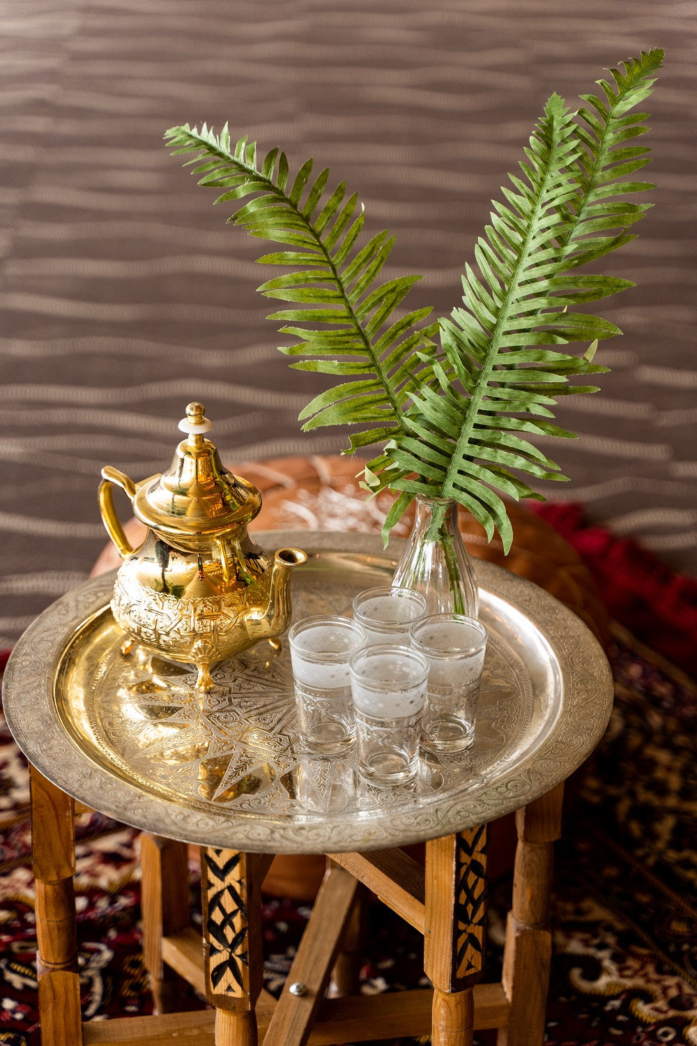 Moroccan tea glasses on a tray with a gold teapot, highlighting elegant frosted and platinum style, perfect for events or special occasions.