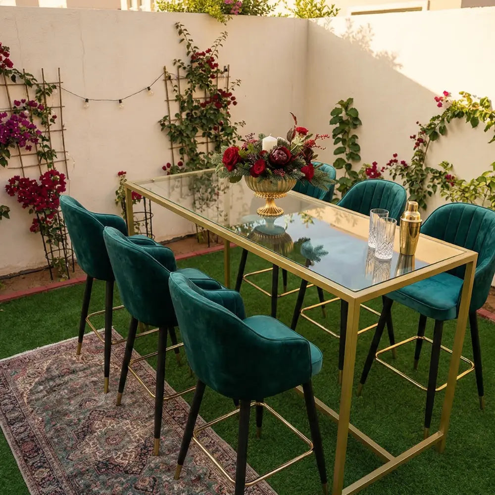 HIGH GLASS RECTANGULAR TABLE W/ GOLD BASE for events, shown with emerald barstools and floral centerpiece, perfect for stylish gatherings and rentals at Party Social.