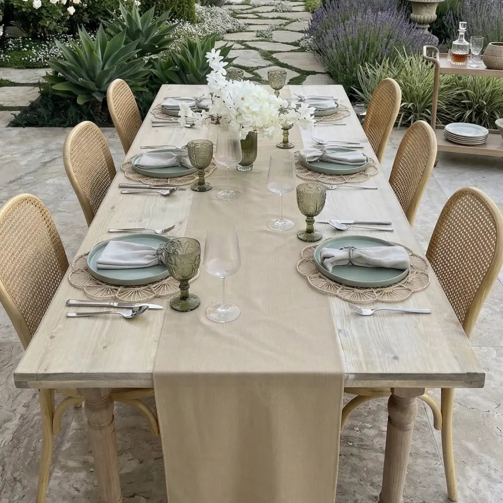 Linen Blend Table Runner elegantly drapes an outdoor dining table, complemented by rattan chairs and coordinated tableware, ideal for special occasions.