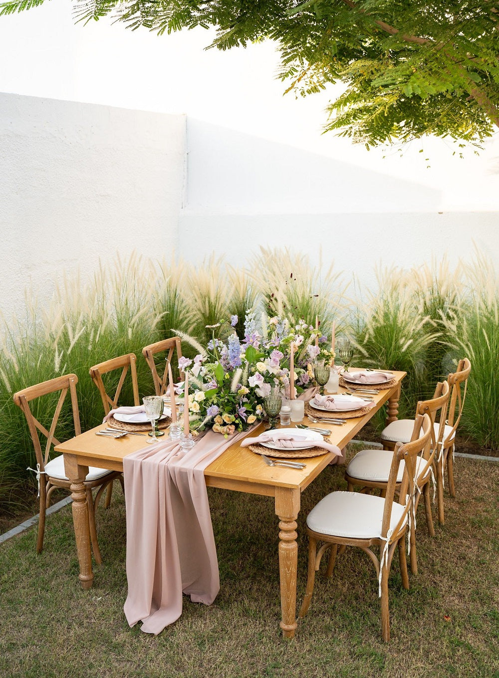 WOODEN DINING TABLE set for a dinner party with flowers and plates, showcasing its use for events and seating up to eight people.