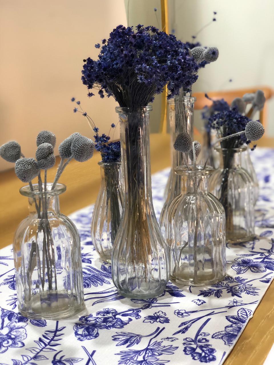Mini clear vases on a table, showcasing various shapes ideal for floral arrangements or candles, perfect for elegant party or event decor.