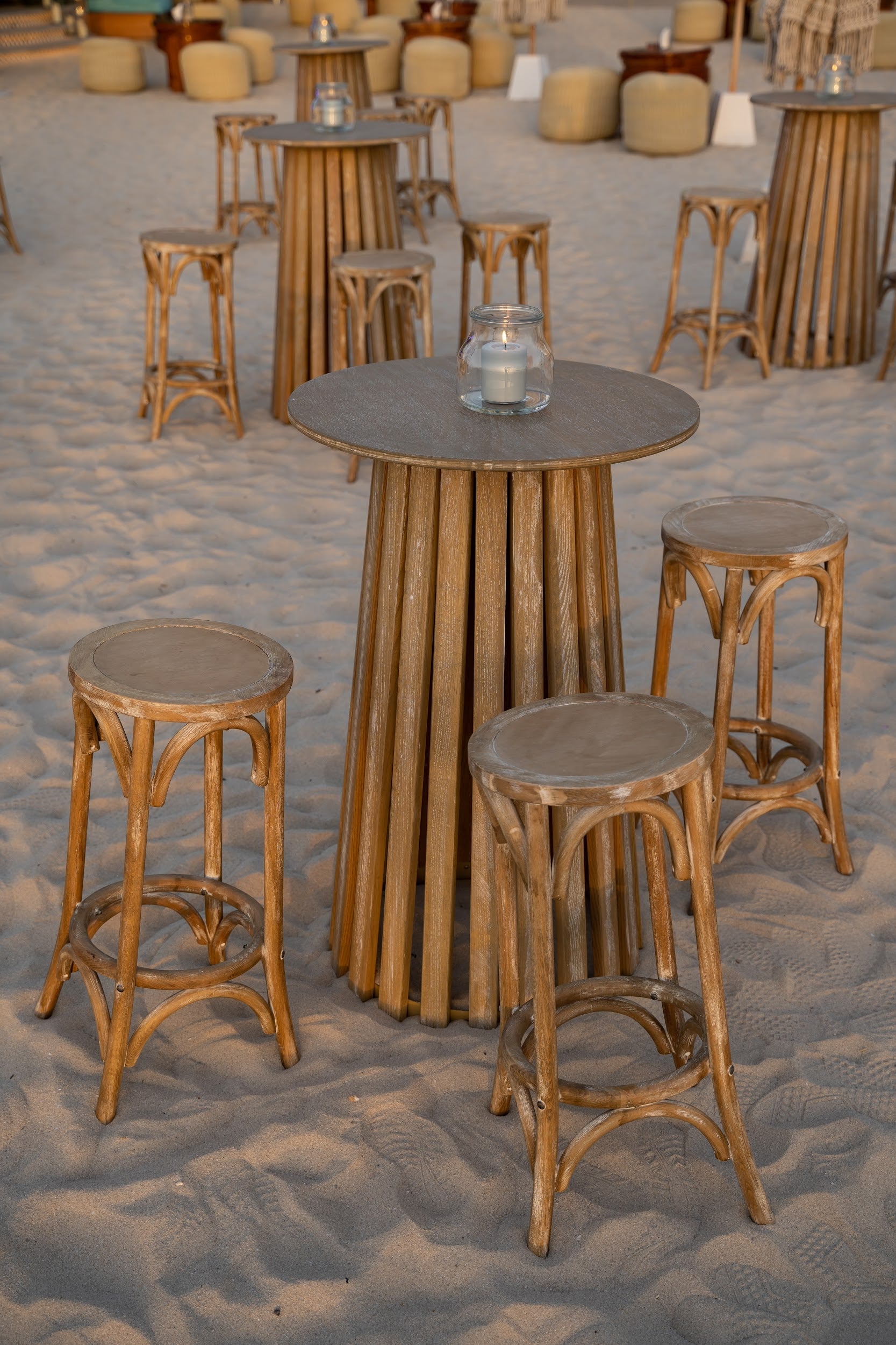 Mini clear vases displayed on a sandy surface, ideal for holding flowers or candles, enhancing event settings with elegance. Timeless accessory for tables or consoles.