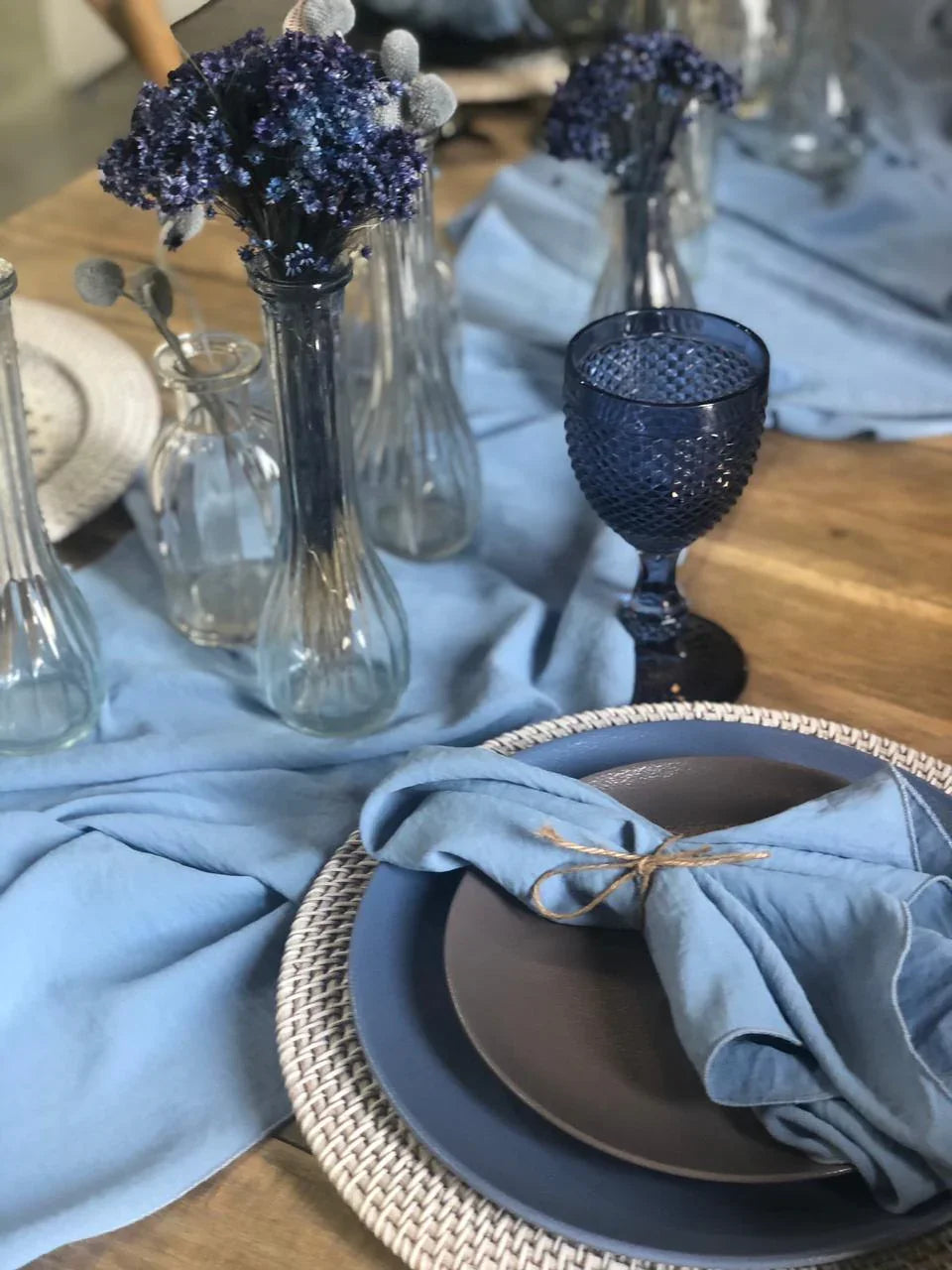 Mini clear vases displayed on a set table, showcasing their versatility for holding flowers or candles, ideal for enhancing any party or event setting.