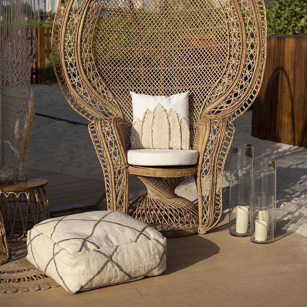 FABRIC & JUTE POUFS on a wicker chair with candles and pillows on a patio, showcasing their versatility as a decorative or functional event piece.