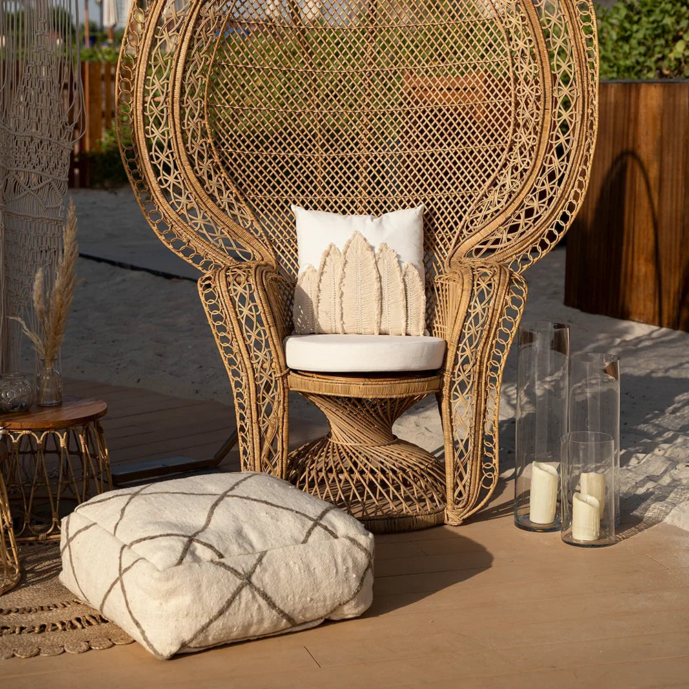 FABRIC & JUTE POUFS on a wicker chair with candles and pillows on a patio, showcasing their versatility as a decorative or functional event piece.