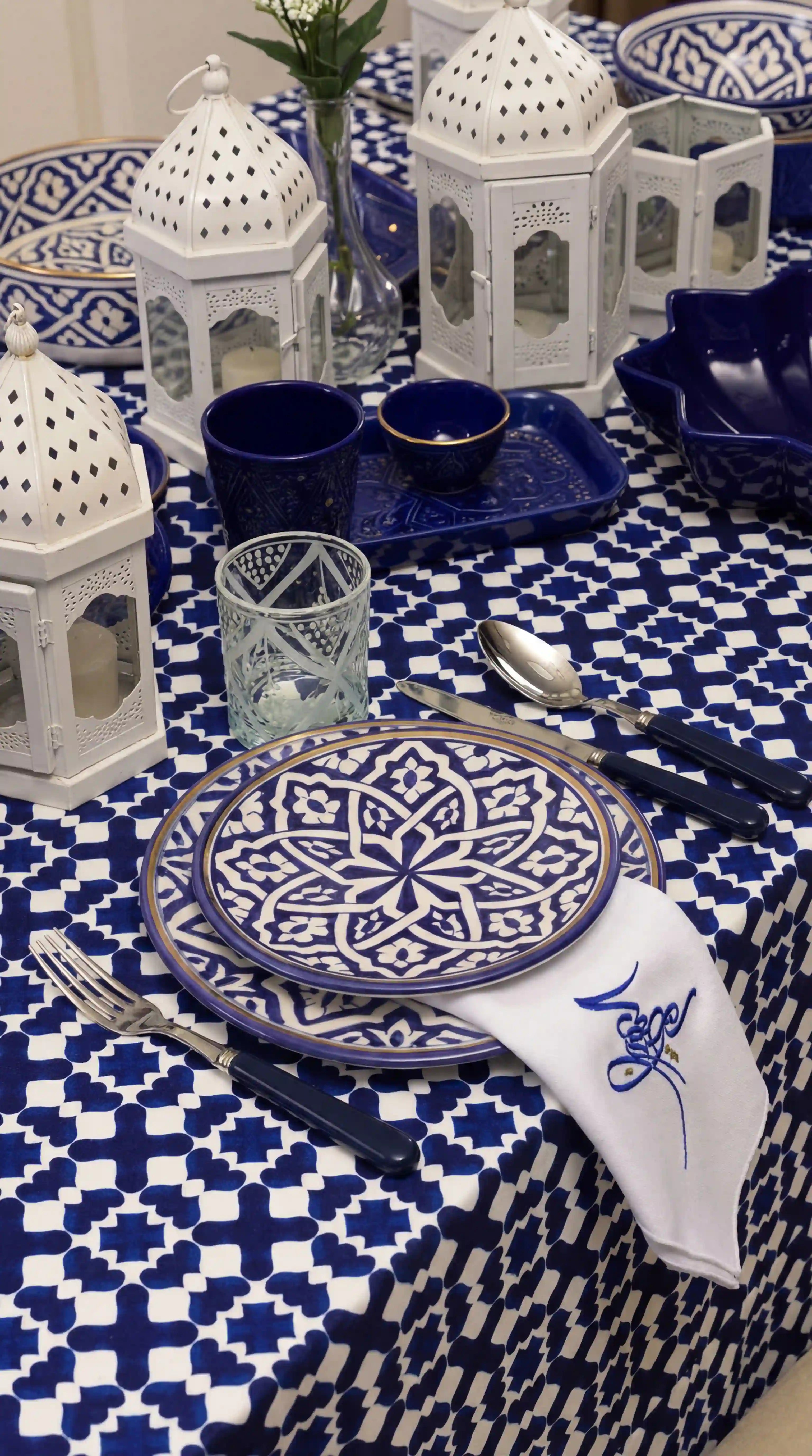 Marrakesh Linen Tablecloth in cobalt blue, showcasing a geometric pattern, forms the centerpiece of a stylish Moroccan-themed tablescape with coordinating ceramics and accessories.