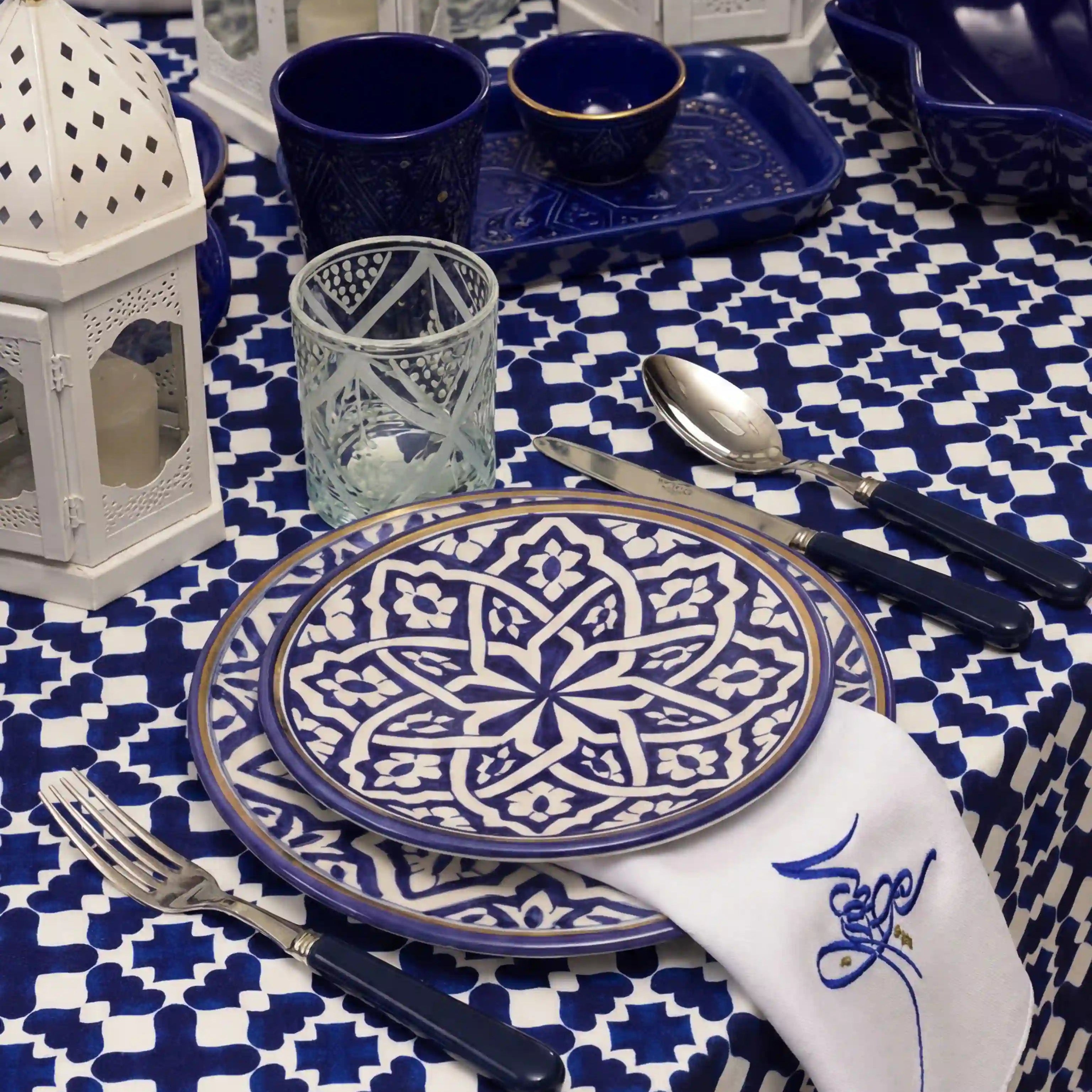 Marrakesh Linen Tablecloth in cobalt blue, showcasing a geometric pattern, forms the centerpiece of a stylish Moroccan-themed tablescape with coordinating ceramics and accessories.