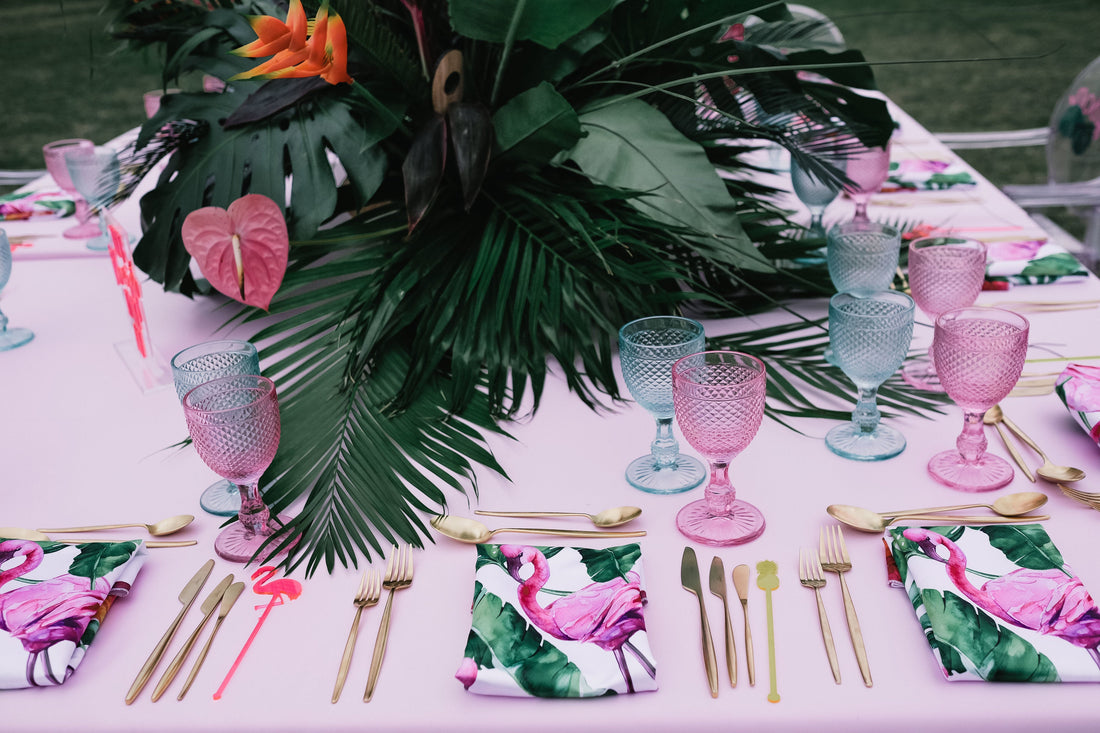 NAPKIN - FLAMINGO SATIN displayed on a table with pink and gold utensils, emphasizing its premium satin texture and elegant flamingo design.